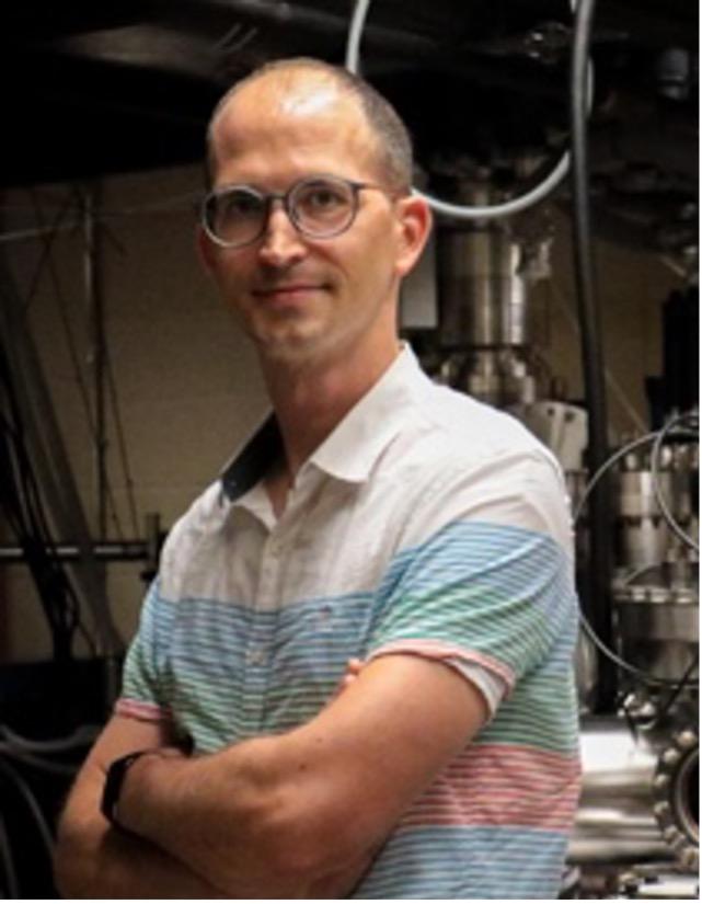 Headshot of man in blue shirt