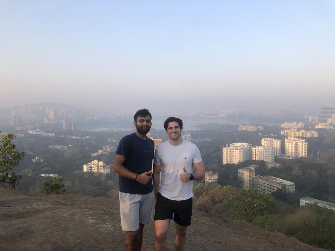 Nathan Gajowski and unknown person standing on a cliff overlooking a city