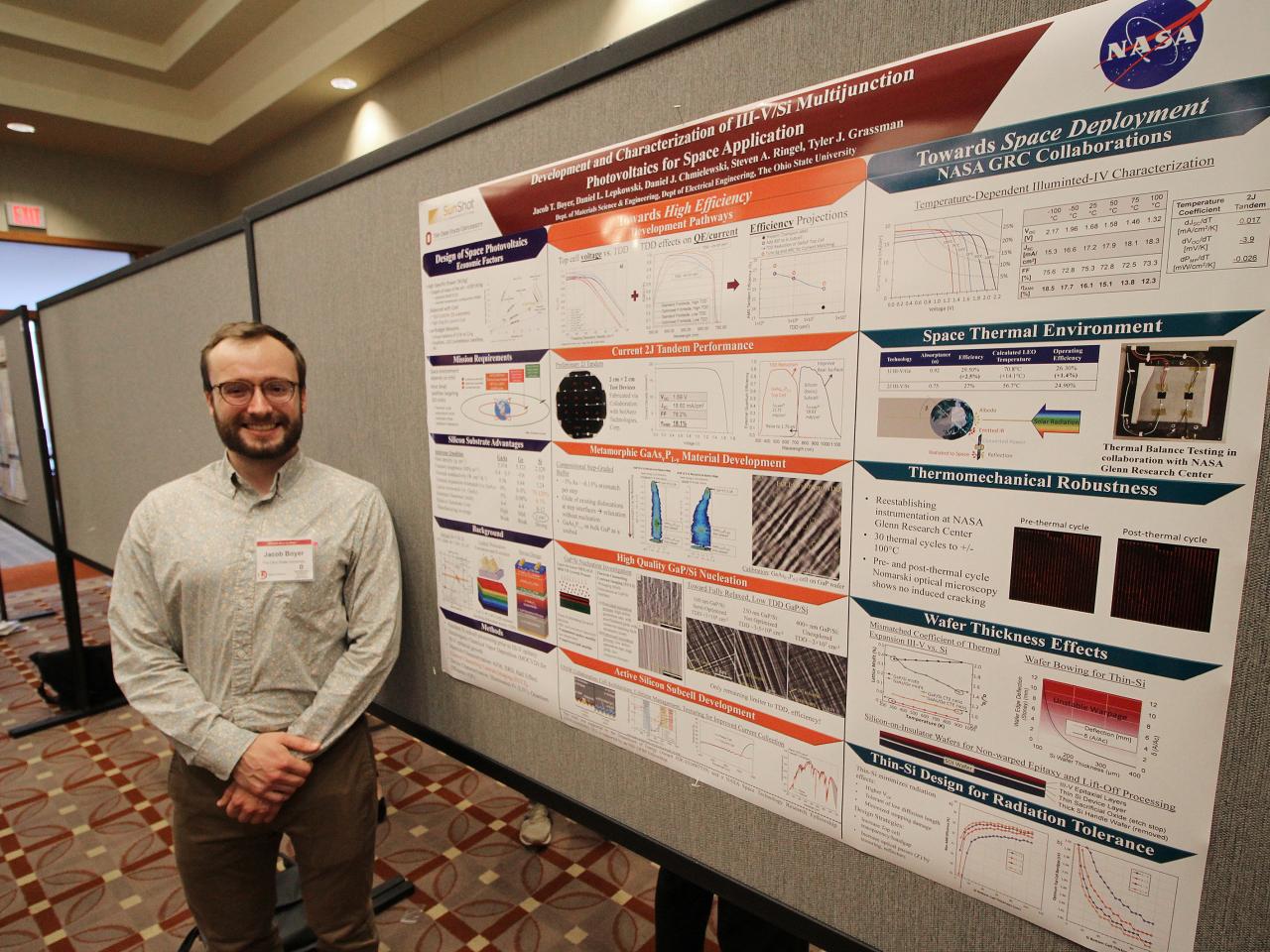 Man proudly standing in front of his poster