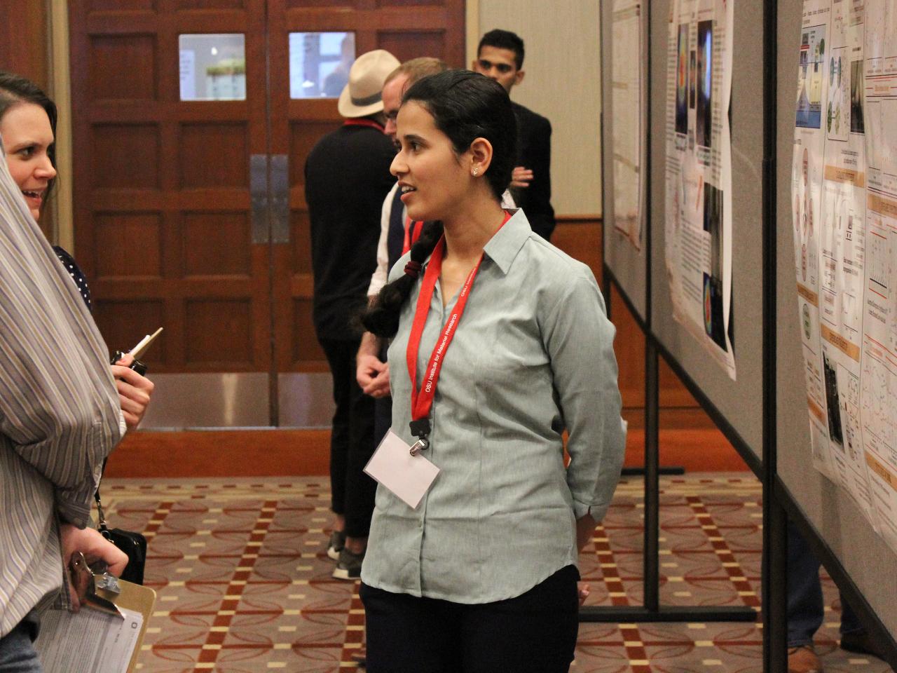 Woman discussing her poster to visitors