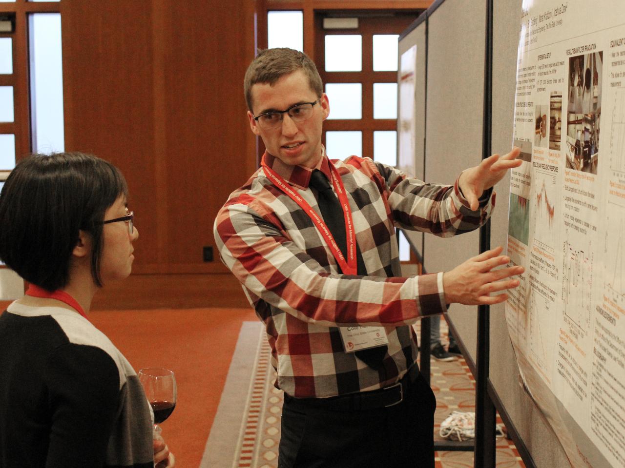 Man gesturing to his poster as he talks