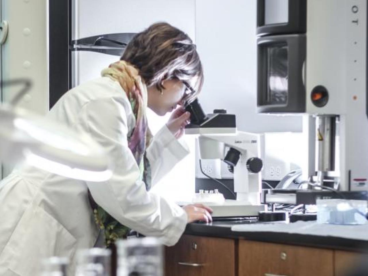 a female researcher using a microscope