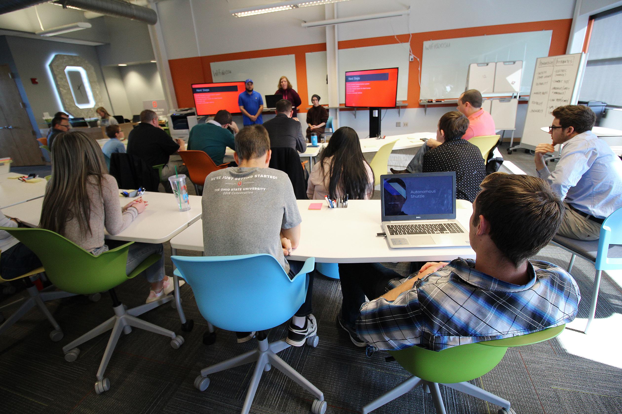 Group of people listening to a speaker present