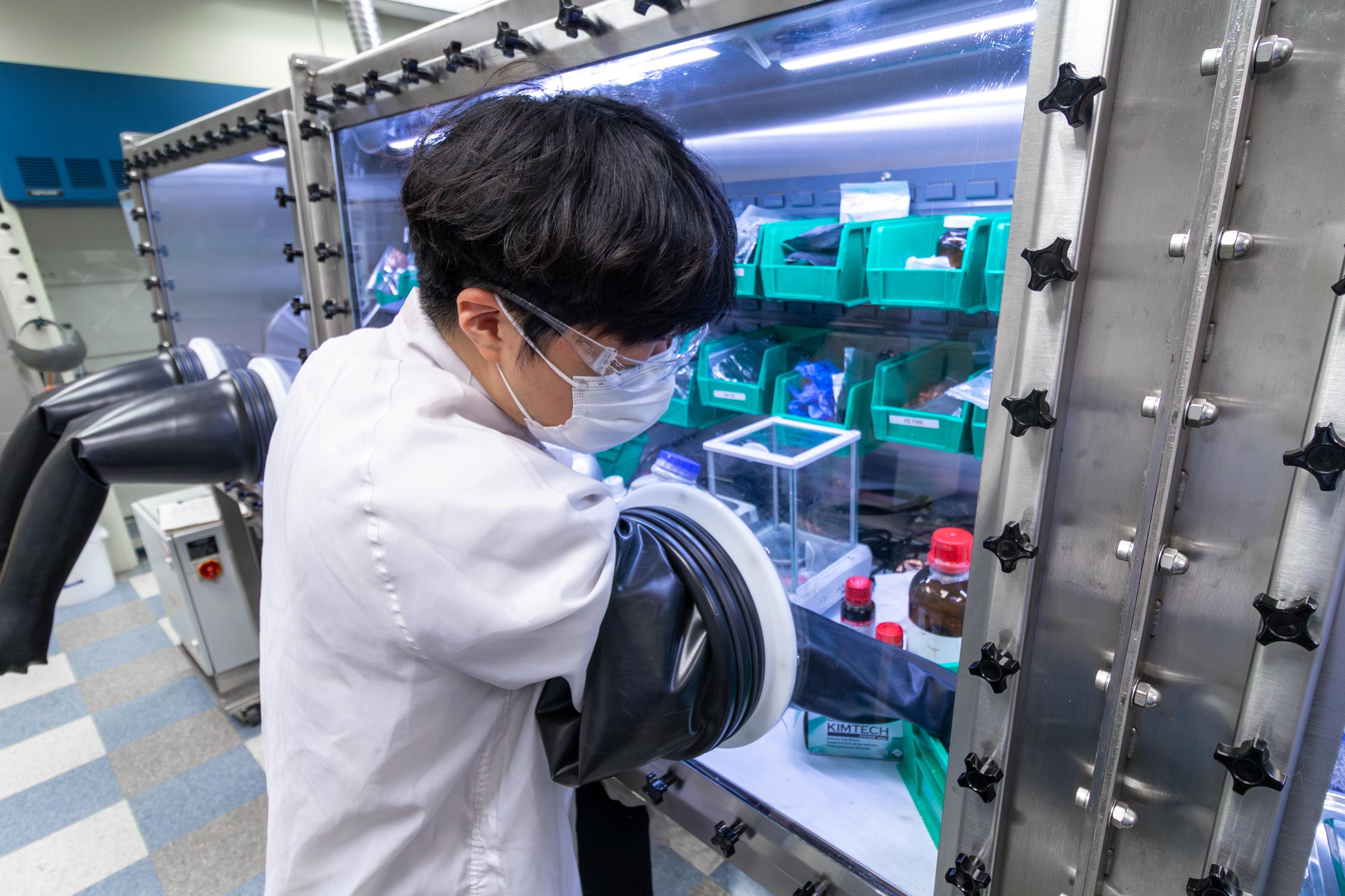 Student working in at a glovebox in the Energy Innovation Lab at Ohio State.
