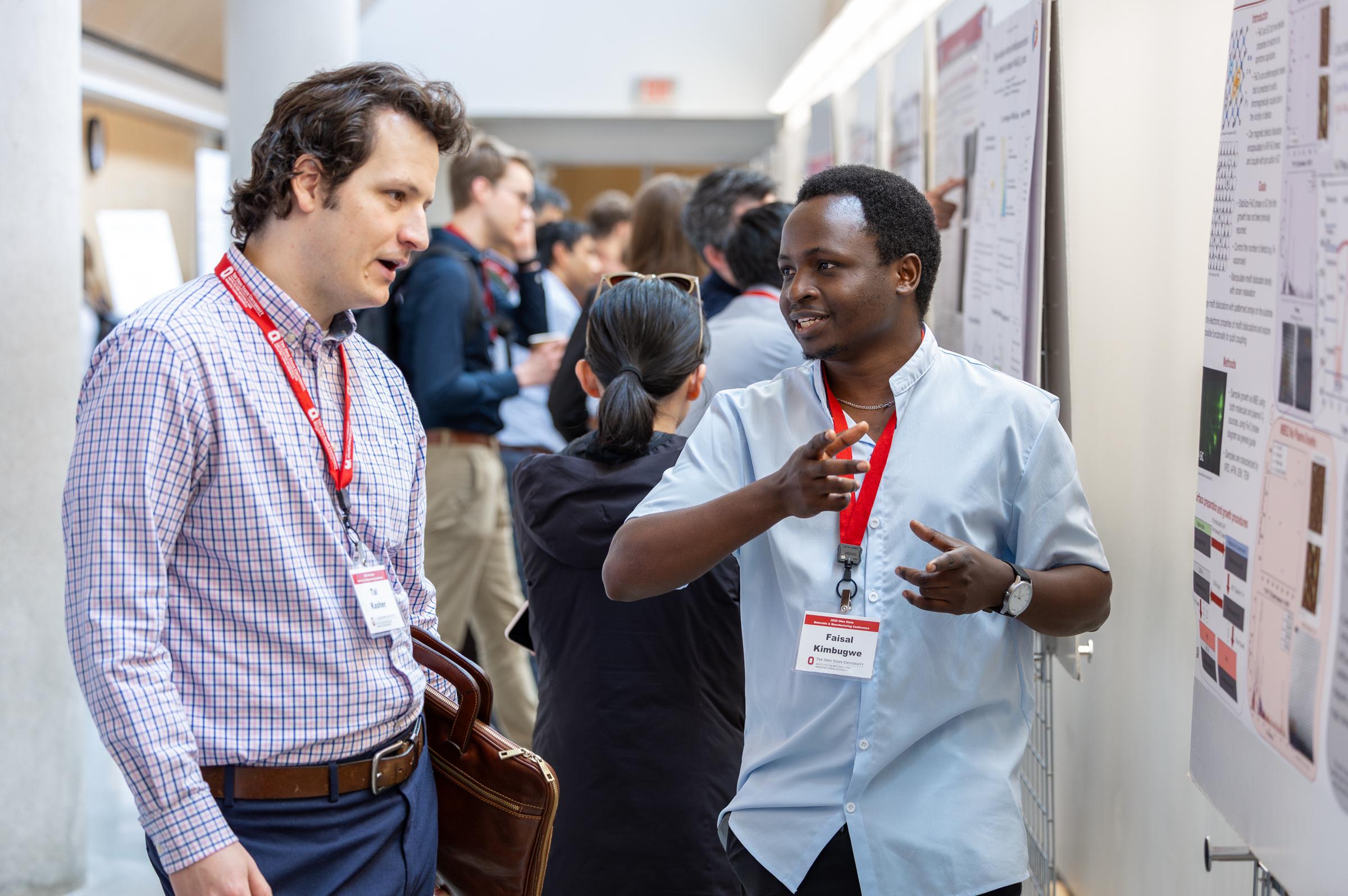 Students discuss a research poster at MMC '25.