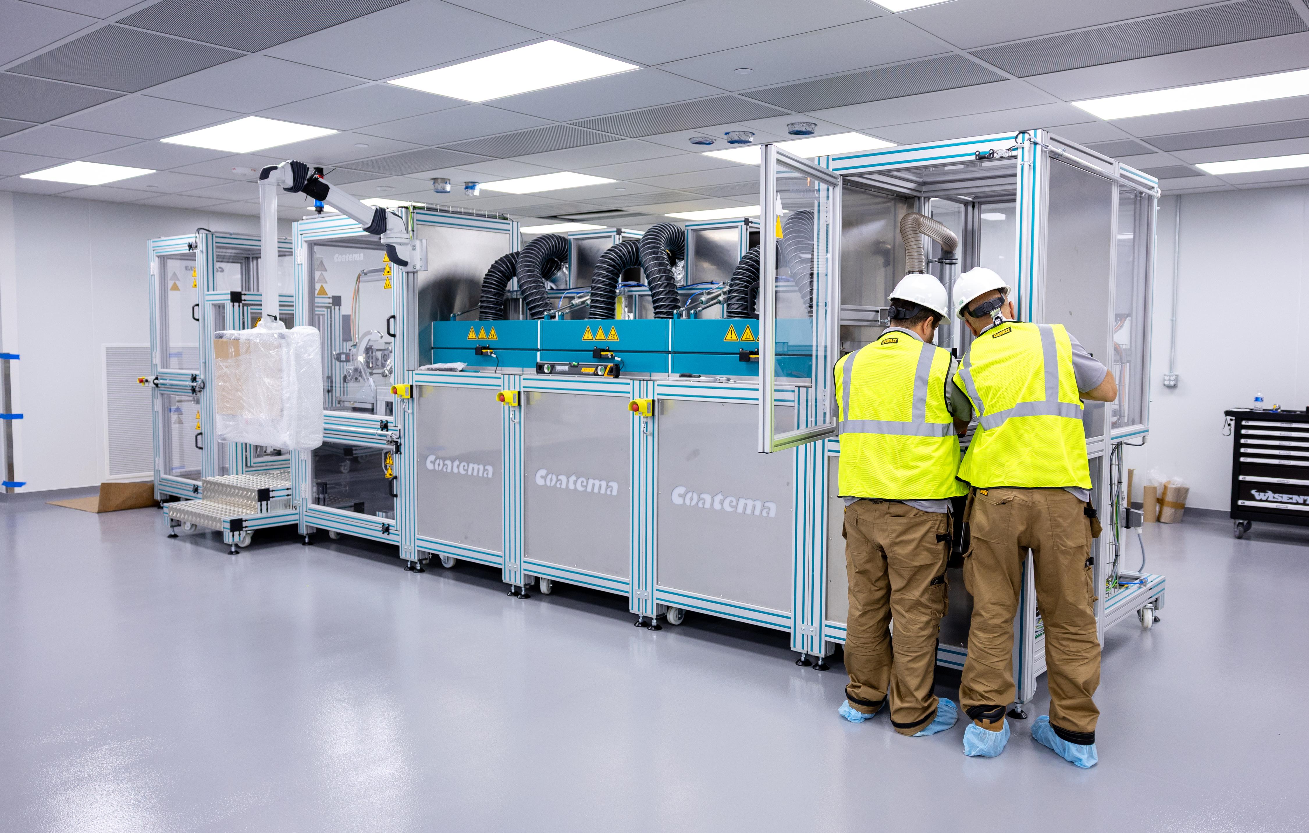 Workers set up a coating machine for battery cell production at Ohio State's Battery Center.