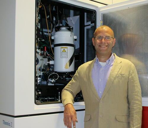 Materials Science and Engineering Associate Professor Robert E.A. Williams posing by an instrument at The Ohio State University’s Center for Electron Microscopy and Analysis (CEMAS).