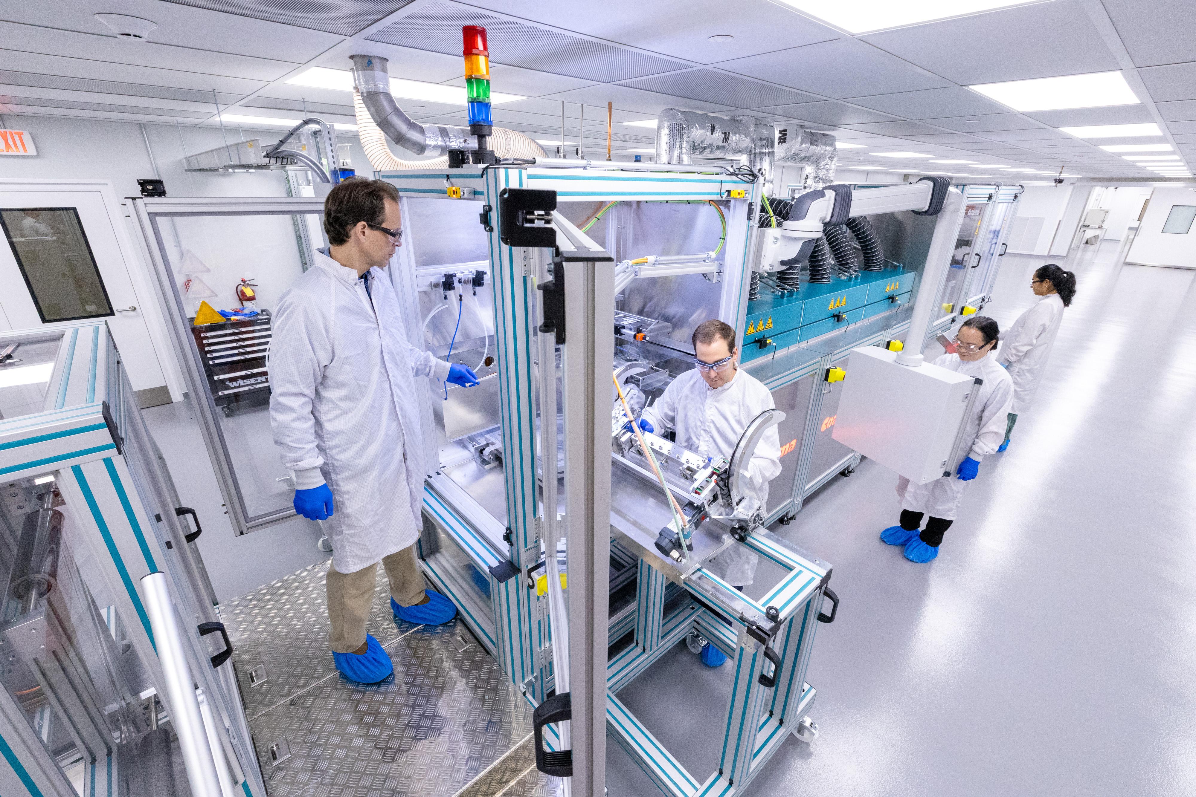 Staff at the Battery Cell R&D Center work at a coating machine.