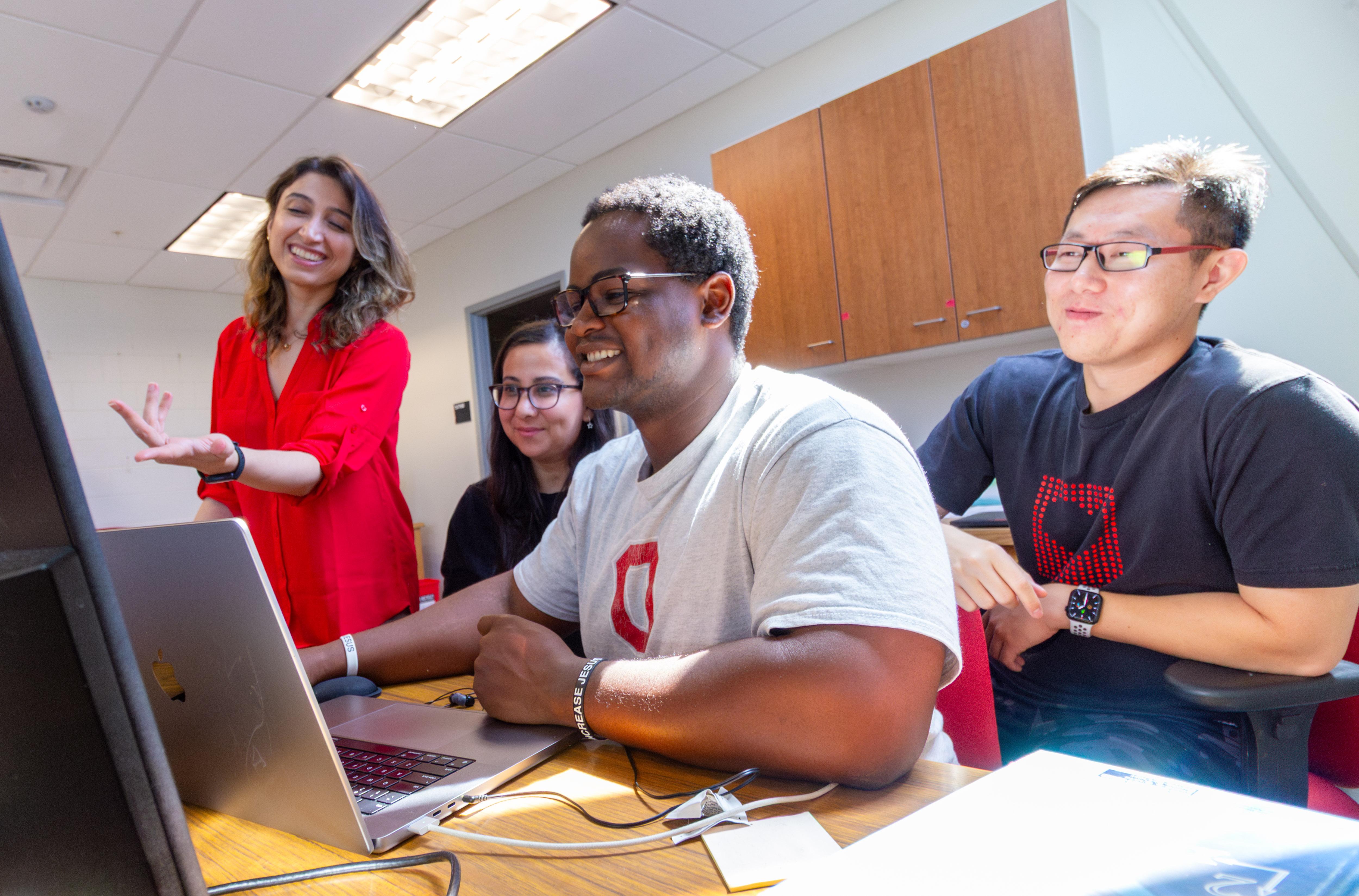 Maryam Ghazisaeidi with students working at a computer.