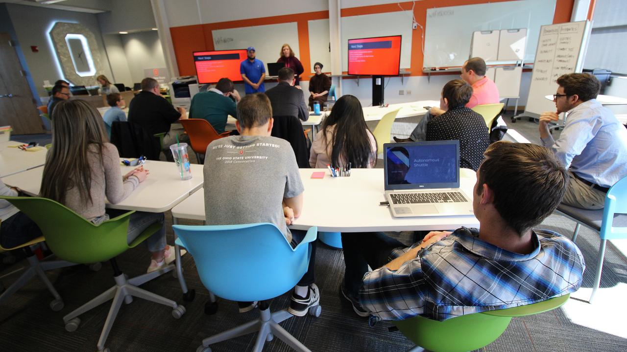 Group of people listening to a speaker present